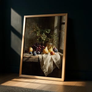 May include: A framed still life painting featuring a rustic wooden table with a white cloth. The table displays a collection of fruits, including grapes, pears, figs, and peaches. A vase with greenery sits in the background, with sunlight streaming through a window.