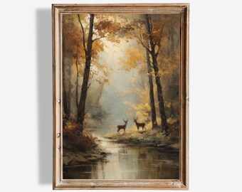 May include: A framed landscape painting depicts a serene forest scene with a river and two deer. The artwork features warm autumn colors, with golden and brown hues dominating the trees and foliage. The painting is signed "GOLDEN ARTS GALLERY".