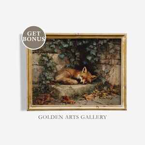 May include: A framed painting depicts a sleeping fox in a natural setting. The fox, with reddish-brown fur, rests on a stone ledge, surrounded by ivy and fallen leaves. The artwork has a golden frame and the text "GOLDEN ARTS GALLERY".
