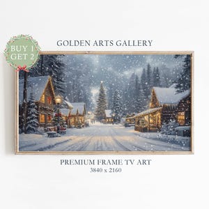 May include: A framed winter landscape painting depicts a snow-covered village with illuminated houses and a Christmas tree. The artwork features a snowy road, evergreen trees, and the text "GOLDEN ARTS GALLERY" and "PREMIUM FRAME TV ART".