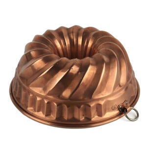 Könnte beinhalten: Kupferfarbene Gugelhupf-Backform mit geriffeltem Design. Die Form hat einen Ring zum Aufhängen und besteht aus glänzendem, rotbraunem Metall. Die Form ist zum Backen von Kuchen bestimmt und hat eine dekorative Form.
