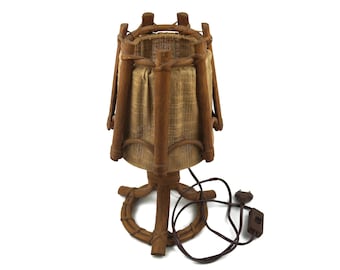 May include: A brown bamboo table lamp with a woven fabric shade. The lamp has a cord and plug.