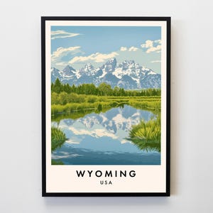 Könnte beinhalten: Ein gerahmter Kunstdruck mit einer ruhigen Landschaft von Wyoming, USA. Das Kunstwerk zeigt eine Bergkette mit schneebedeckten Gipfeln, die sich in einem ruhigen See spiegeln. Saftig grüne Vegetation säumt das Ufer unter einem blauen Himmel mit flauschigen Wolken. Das Wort "WYOMING" ist unten aufgedruckt.
