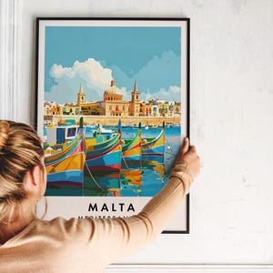 May include: A colorful poster with a view of a city in Malta. The poster features a cityscape with buildings and boats in the harbor. The text "MALTA MEDITERRANEAN" is at the bottom of the poster.
