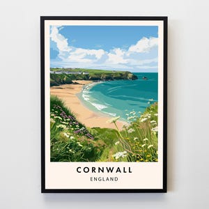 May include: A framed art print featuring a coastal scene in Cornwall, England. The artwork depicts a sandy beach, turquoise water, green cliffs, and a bright blue sky with fluffy white clouds. The print includes the text "Cornwall England" at the bottom.