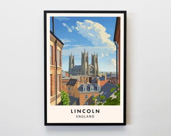 May include: A framed art print featuring a stylized illustration of Lincoln Cathedral in England. The artwork depicts the cathedral against a blue sky with fluffy clouds, viewed from a street lined with buildings. The text "LINCOLN ENGLAND" is at the bottom.