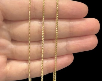 May include: Three gold chains of different lengths, displayed on a hand.