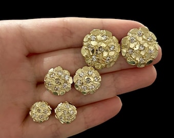 Könnte beinhalten: Ein Satz mit vier goldenen Ohrringen mit einer strukturierten Oberfläche und klaren Steinen. Die Ohrringe sind in verschiedenen Größen.