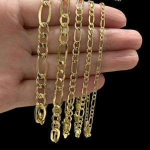 May include: Five gold chains of different widths, ranging from 2.5mm to 7mm, are displayed on a hand. The chains are all made of a classic, flat, oval-shaped link design. The text "7mm 5.4mm 4.5mm 3.5mm 2.5mm" is printed above the chains.