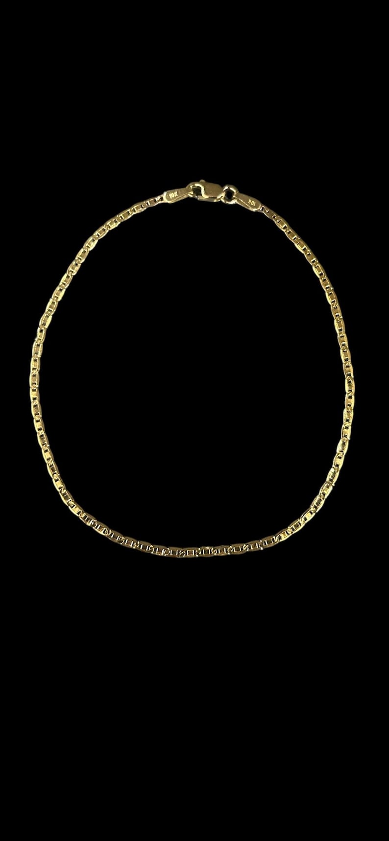 Pu&ograve; includere: Una collana color oro con un delicato design a catena. La collana &egrave; esposta su uno sfondo nero, evidenziando il suo aspetto lucido e metallico. La chiusura &egrave; visibile in alto.