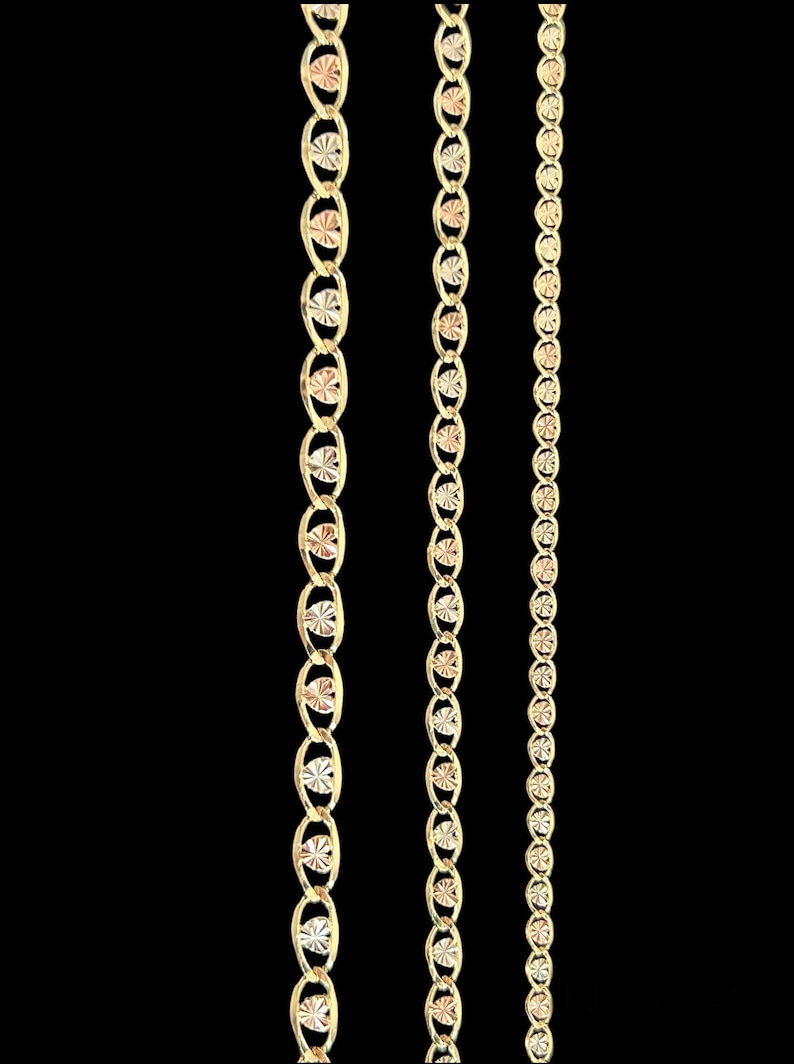 May include: Three gold chains with a diamond-cut design. The chains are different lengths and widths.