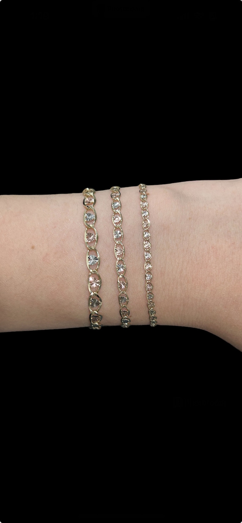Puede incluir: Tres pulseras de oro con un patr&oacute;n de diamante en la mu&ntilde;eca de una persona. Las pulseras tienen diferentes anchos.