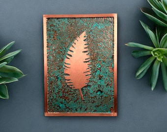 May include: A copper plaque with a textured, teal-green background and a raised, copper leaf design.