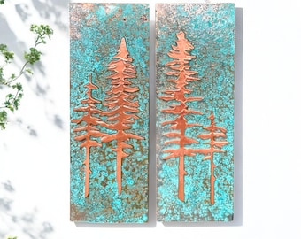 May include: Two rectangular copper wall art pieces with a turquoise patina. Each piece features a raised copper design of three pine trees.