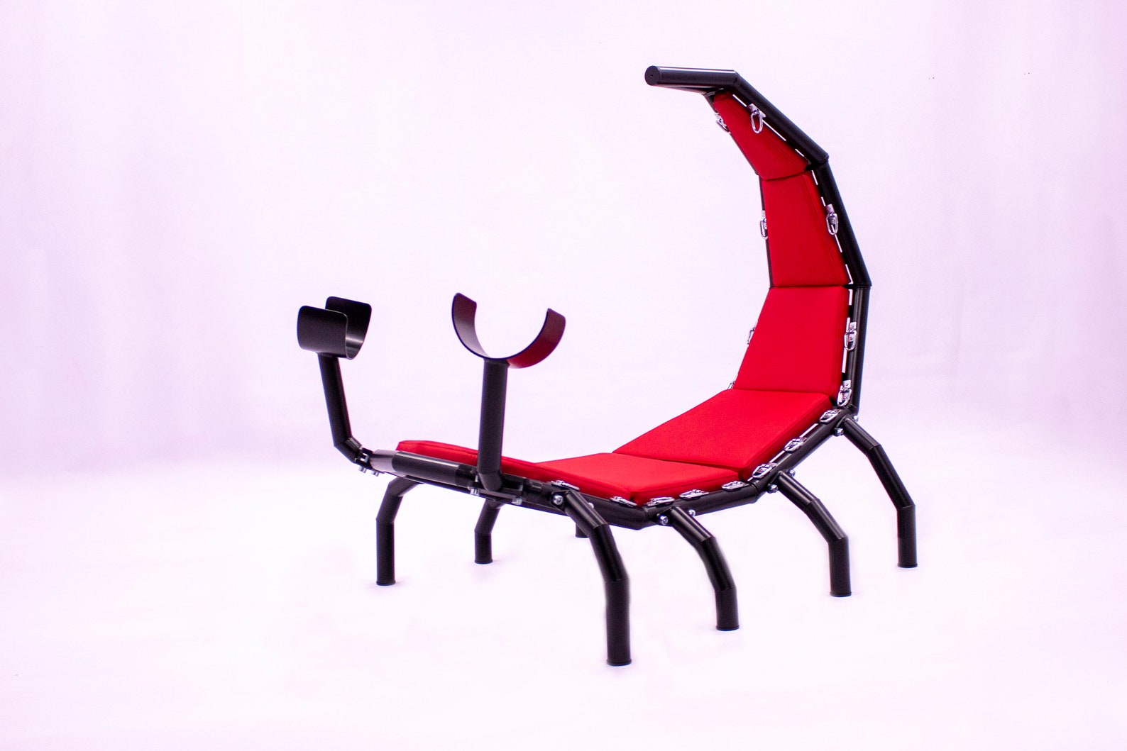 Scorpio BDSM chair in red faux leather with black steel frame, featuring bondage restraints and upright stinger design