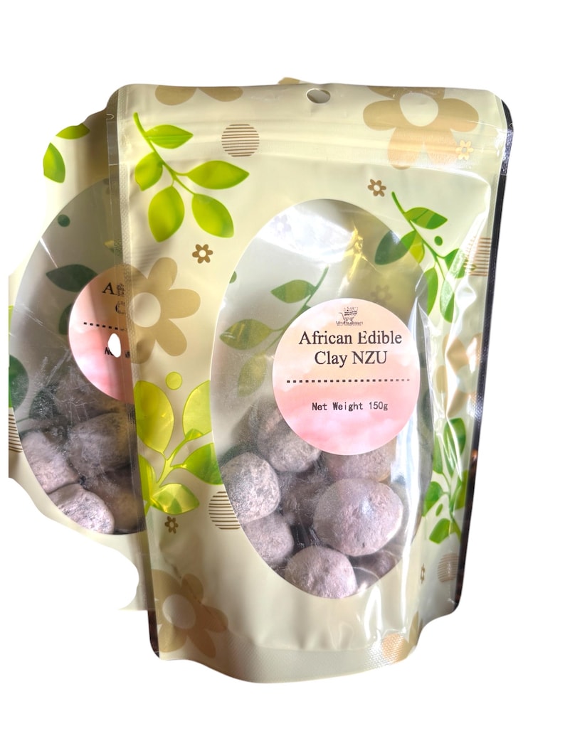May include: A resealable bag with a clear window showing edible African clay Nzu. The bag is cream colored with a green floral pattern and the text "African Edible Clay Nzu" and "Net Weight 150g".