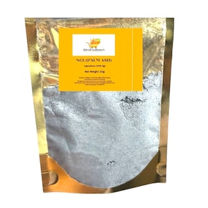 Pode incluir: Uma bolsa dourada com um rótulo amarelo que diz "AfroFoodmart" e "NGU(PALM ASH)". O rótulo também inclui o texto "Ingredientes: 100% Ngu" e "Peso líquido: 50g". A bolsa contém um pó cinzento.