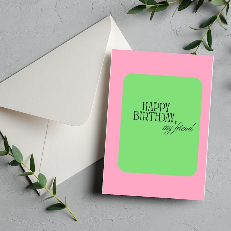 May include: A birthday card with a pink border and a green center. The card reads "HAPPY BIRTHDAY, my friend" in black text. An envelope is visible in the background.