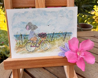 Acuarela original: Un ratoncito en bicicleta junto al mar | Ilustración suave y veraniega