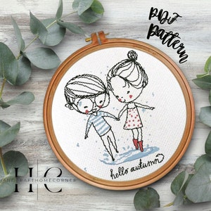 May include: A cross-stitch pattern featuring a cartoon couple in rain boots, holding hands and walking through a puddle. The text "hello autumn" is written below them.