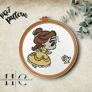 May include: A cross-stitch pattern of Belle from Beauty and the Beast, with a yellow dress and brown hair, looking at a small yellow teapot with a blue handle. The pattern is in a wooden embroidery hoop.