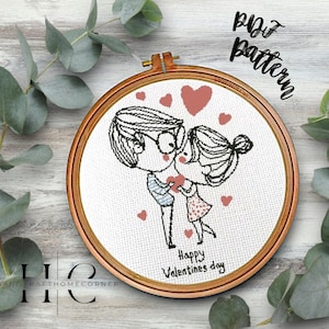 May include: A cross-stitch embroidery hoop featuring a couple embracing, holding a heart, and kissing. The design is in black and white with red hearts. Text reads "Happy Valentines day" and "PDF pattern".