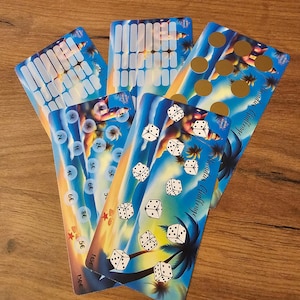 Peut inclure: Plusieurs cartes de jeu colorées sur le thème tropical. Les cartes présentent des dés, des palmiers et le texte "Paradies Challenge". L'arrière-plan montre un coucher de soleil aux couleurs bleu, orange et jaune. Certaines cartes ont des cercles dorés ou des rectangles blancs.