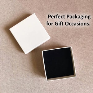May include: Two white square boxes, one open and one closed. The closed box has a black velvet interior. The text 'Perfect Packaging for Gift Occasions.' is printed in black above the boxes.
