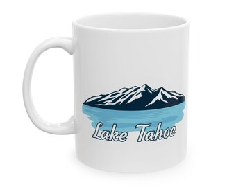 May include: White ceramic mug featuring a blue and black illustration of a mountain range reflected in a body of water. The text "Lake Tahoe" is printed below the image.