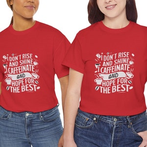 May include: Two red t-shirts with a white graphic design. The graphic design features a coffee cup and the text "I don't rise and shine I caffeinate and hope for the best".
