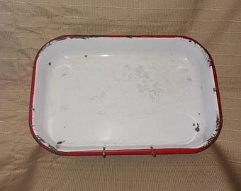 Molde rectangular de esmalte blanco para hornear con borde rojo.