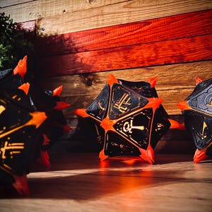 May include: Four black and orange dice with glowing yellow numbers. The dice are illuminated from within and are sitting on a wooden surface.