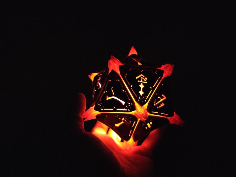 May include: A glowing, multi-sided, black metal dice with orange light shining through the cut-out designs.