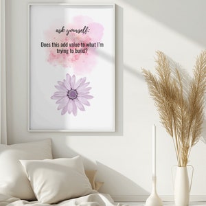 Puede incluir: Una impresión enmarcada en blanco con un fondo de acuarela rosa y una flor morada. El texto en la impresión dice "ask yourself: Does this add value to what I'm trying to build?"
