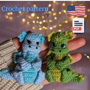 May include: Crochet pattern for two small amigurumi dragons. One dragon is light blue and the other is green. The pattern is available as a PDF download.