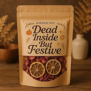 May include: A kraft paper bag labeled "Simmer Pot" with the text "Dead Inside But Festive." The bag contains dried rose petals and two dried orange slices. The overall color scheme is warm and autumnal.