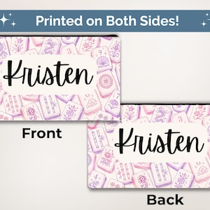 May include: A rectangular zippered pouch featuring a repeating pattern of purple and pink mahjong tiles with floral and dragon motifs. A white central label displays the name Kristen in black script. The pouch is shown from both sides.