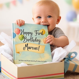 May include: A baby holds a book with the text "Happy First Birthday Marcus!" The book is in a gift box with a blue ribbon. The book cover features colorful balloons and a banner. The text "Written and Illustrated by Kristen McCalla" is also visible.