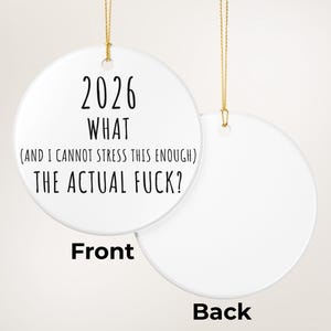 May include: A white ceramic Christmas ornament with gold string. The front of the ornament has the text "2026 WHAT (AND I CANNOT STRESS THIS ENOUGH) THE ACTUAL FUCK?". The back of the ornament is blank and labeled "Back".