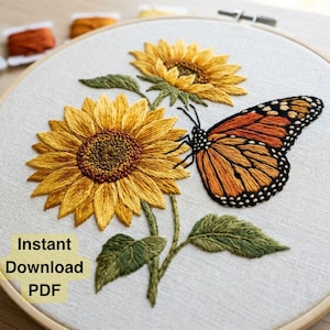 May include: An embroidery hoop containing a fabric piece with a stitched design of two yellow sunflowers and an orange and black monarch butterfly. The text Instant Download PDF is printed in black on a light yellow background in the lower left corner.
