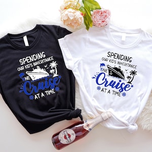 May include: Two black and white t-shirts with a graphic of a cruise ship and the text "Spending our kid's inheritance one cruise at a time".