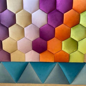 May include: A vibrant wall panel with a geometric design. It features hexagonal shapes in shades of purple, orange, yellow, and green, and triangular shapes in teal and grey. The panel is designed for interior decoration.