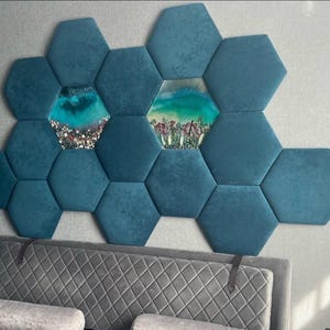 May include: Teal hexagon wall art with embedded resin art pieces. The art features a combination of teal, turquoise, and white resin, with some pieces containing floral elements. The wall art is mounted above a grey upholstered headboard.