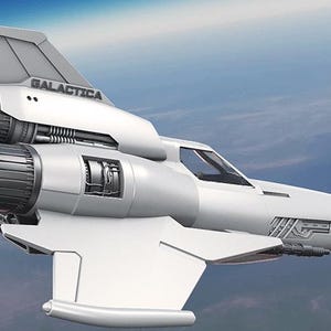 Può includere: Un'astronave bianca con la scritta "GALACTICA" sulla pinna di coda, che vola contro un cielo blu. L'aereo ha tre ugelli motore e un design elegante e aerodinamico, che suggerisce un tema di fantascienza.