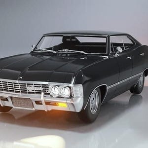 May include: A black classic car with chrome accents, including a front grille and bumpers. The car has a sleek, vintage design with a low profile and a black roof. The headlights and turn signals are illuminated. The car is a 1967 Chevrolet Impala.