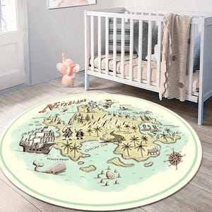 Puede incluir: Una alfombra de juego redonda, de color azul claro y crema, con un mapa de Nunca Jamás. El mapa presenta un barco pirata, un cocodrilo y las palabras "Neverland" y "Cannibal Cove".