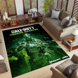 May include: A green and black area rug featuring a Call of Duty: Modern Warfare design. The rug depicts a soldier holding a rifle, with the game's logo and title in the top left corner. The rug also includes the Infinity Ward and Activision logos.