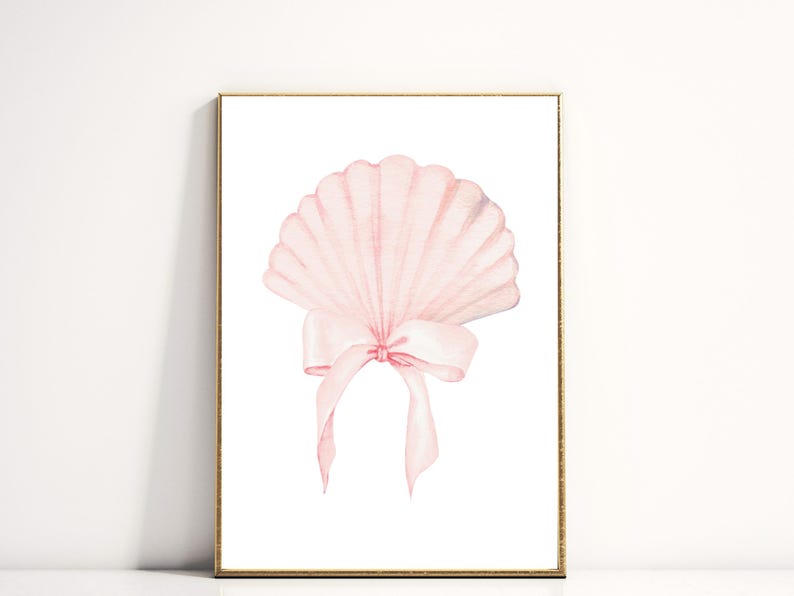 May include: A framed watercolor print featuring a light pink seashell with a delicate bow. The seashell has a fan-like shape with detailed ridges. The bow is tied at the base of the shell, with long, flowing ribbons. The artwork is set against a white background.