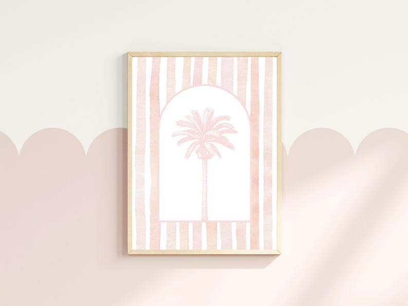 May include: A framed art print featuring a pink palm tree within an archway, set against a backdrop of vertical pink and white stripes. The artwork is displayed on a light pink wall.