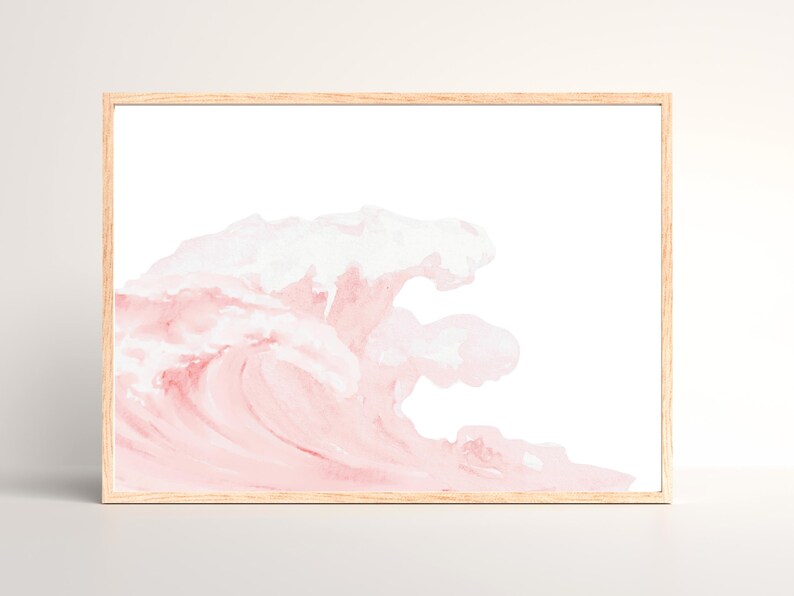 May include: Watercolor print of a wave in shades of pink and white, framed in a light wood frame. The artwork depicts a stylized ocean wave, with soft brushstrokes creating a sense of movement and texture. A decorative piece for home decor.